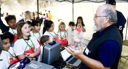 West Hills College's Jim Rooney shows kids a robotic arm and other high-tech equipment.